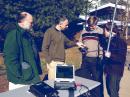 UVA Amateur Radio club trustee Michael McPherson, KQ9P (left); Professor Chris Goyne; and engineering students Colin Mitchell, KN4BBF, and Tyler Gabriele, KN4BBE, prepare to track a satellite using a UHF radio and hand-held antenna. Gabriele is holding what appears to be a lab model of the UVA CubeSat. [Dan Addison/University Communications photo]